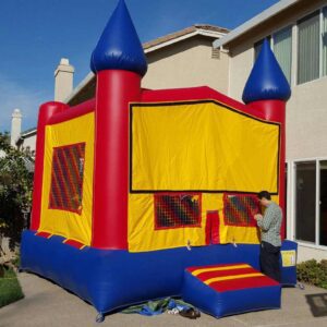 A colorful inflatable bounce house set up in a backyard.