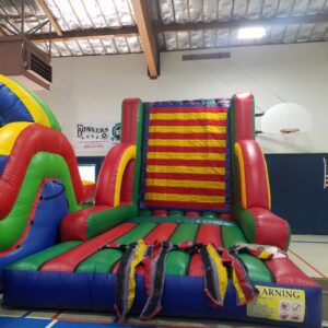 Colorful indoor inflatable slide and obstacle course setup.