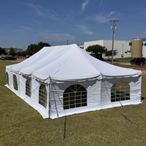 Large white event tent set up on grass under a clear sky.